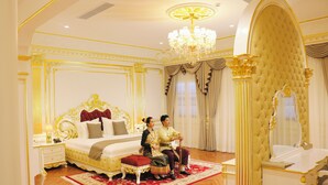 Une chambre à coucher luxueuse, dotée d’un grand lit, d’une décoration raffinée et d’un lustre.