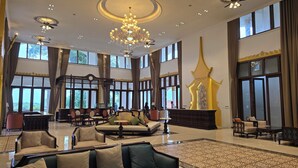 Eine geräumige Lobby mit hohen Decken, großen Fenstern und einem prächtigen Kronleuchter.