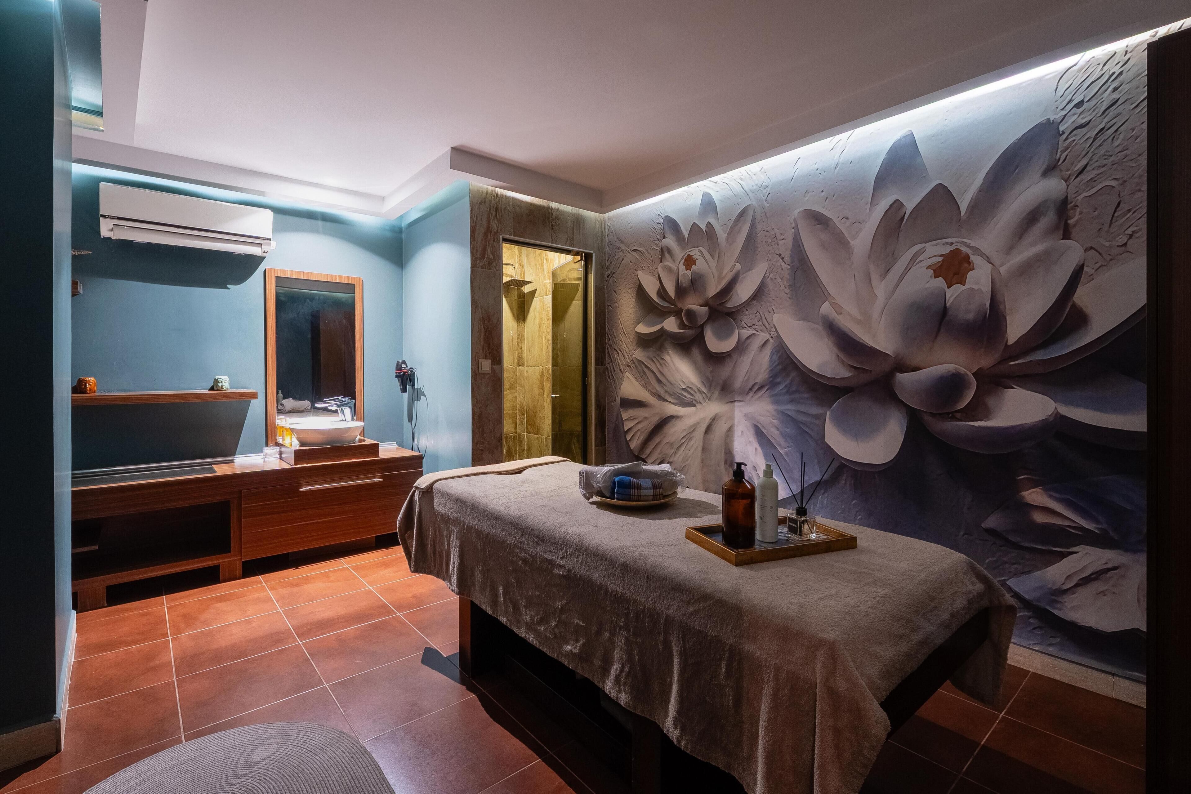 A bathroom with a large floral mural, a vanity with a mirror, and a shower area.