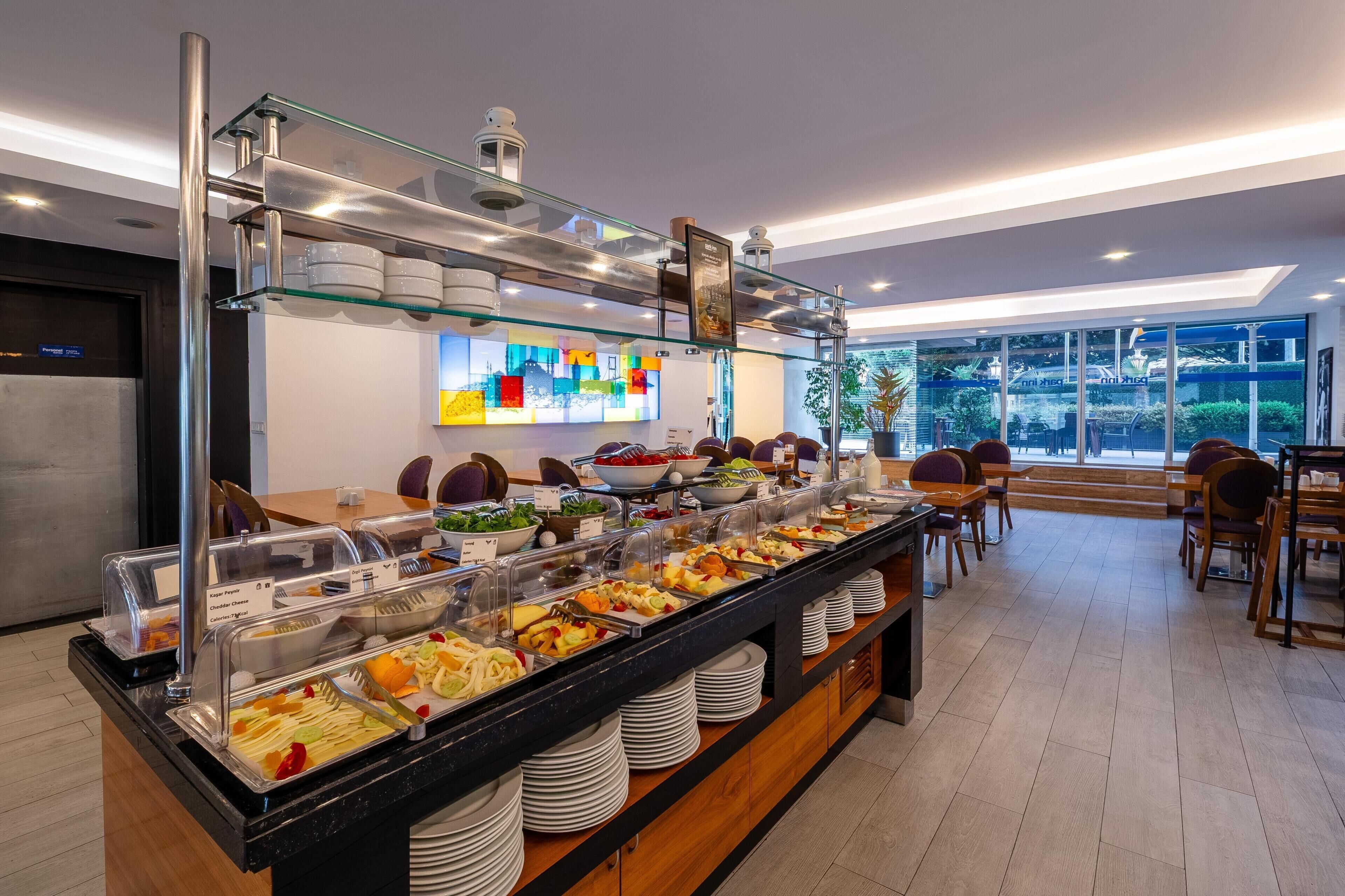 A buffet area with various food options, a glass display case, and a seating area with tables and chairs.