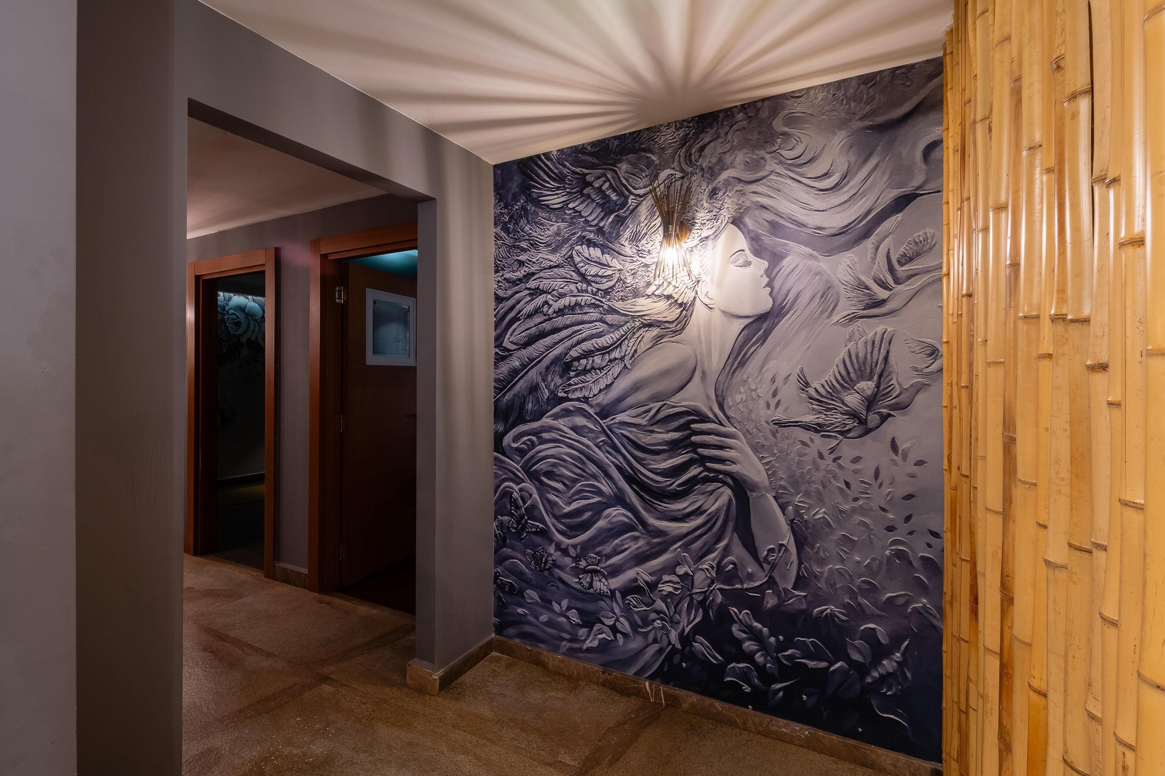 A hallway with a large wall mural featuring a woman and birds.