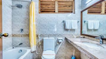 A bathroom with a bathtub, toilet, shower, and sink.