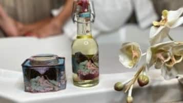 Un baño con una bañera, una botella de líquido y una caja decorativa.