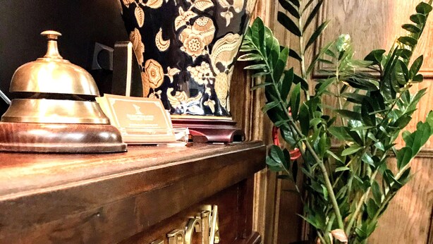 A reception desk with a wooden finish and a nameplate that reads "RECEPTION". - SleepWalker Boutique Suites (Wroclaw)