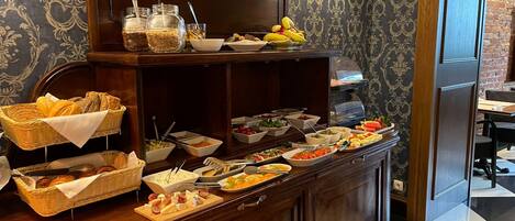 A buffet setup with various food items and utensils.