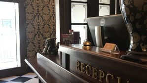 A reception desk labeled "RECEPTORIA" with a computer, a lamp, and a decorative vase. - SleepWalker Boutique Suites (Wroclaw)