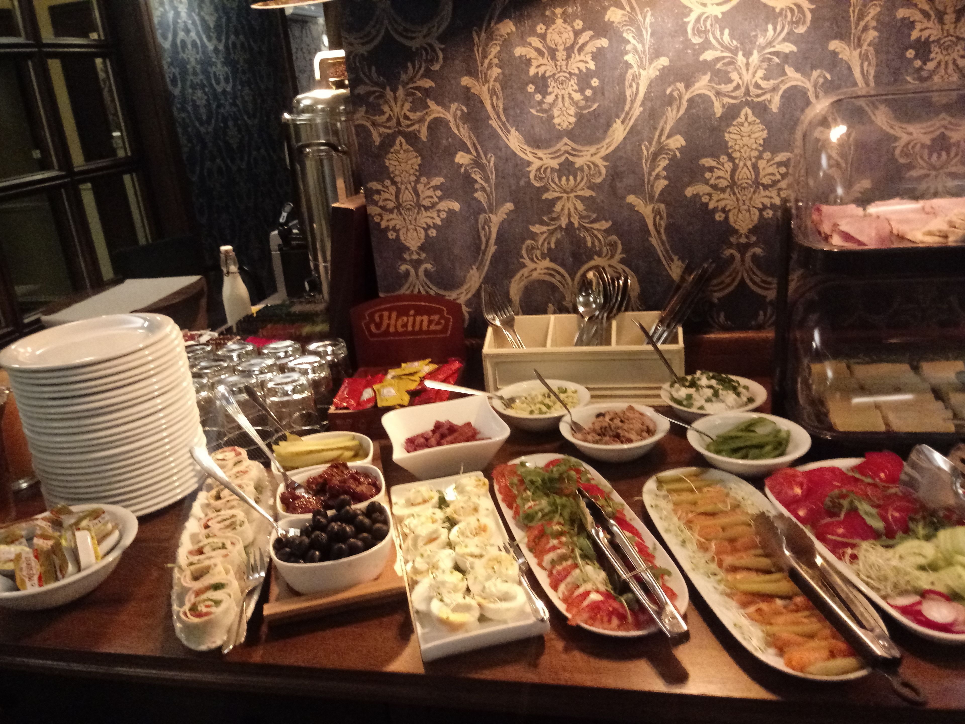 A buffet table with various dishes and condiments.