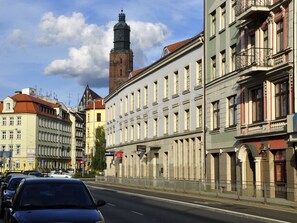 A street with historic buildings, a prominent tower, and parked cars. - SleepWalker Boutique Suites (Wroclaw)