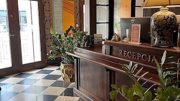 A reception area with a checkered floor, a reception desk, and a lamp.