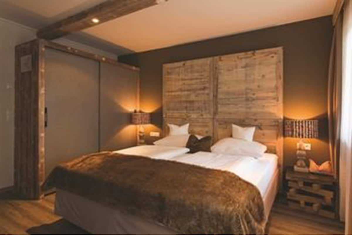 Un dormitorio con una cama grande, dos mesitas de noche y un cabecero de madera.