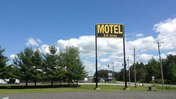A motel sign with a 24-hour service indication.