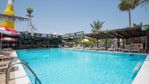 A swimming pool with lounge chairs and umbrellas, a restaurant, and a bar. - Kkaras Hotel (Ayia Napa)