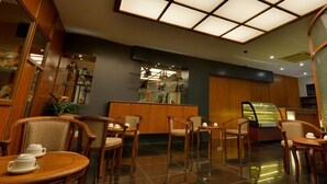 A hotel lobby with wooden furniture, a reception desk, and a glass display case. - Asiana Hotel (Kota Kinabalu)