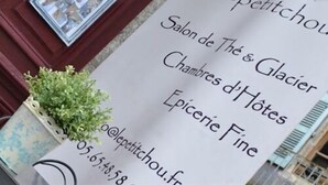 A sign for a hotel named 'CH lepetitchou.fr' with contact information and services listed, including 'Salon de Thé & Glacier', 'Chambres d'Hôtes', and 'Epicerie Fine'. - Le Petit Chou (Entraygues-sur-Truyere)
