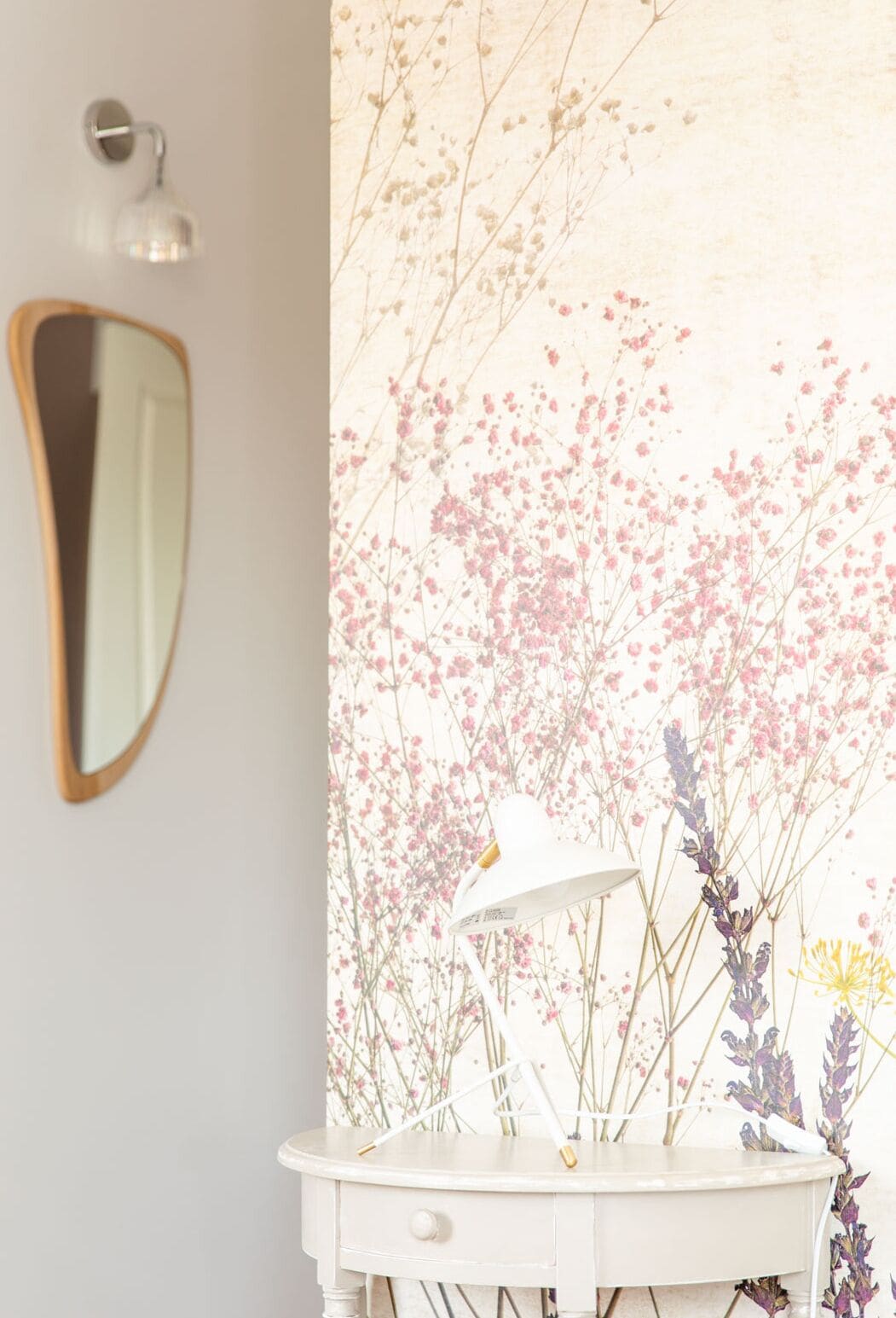 Un meuble-lavabo pour la salle de bain avec un plan de toilette blanc, un miroir et une lampe.