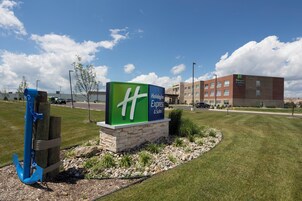 A Holiday Inn Express & Suites sign with a clear view of the building in the background.