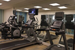 A gym with treadmills, stationary bikes, and a television mounted on the wall. - Holiday Inn Express & Suites Monroe by IHG (Monroe)