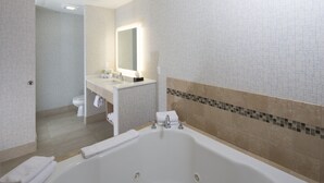 A modern bathroom with a large bathtub, a sink, and a toilet. - Holiday Inn Express & Suites Monroe by IHG (Monroe)