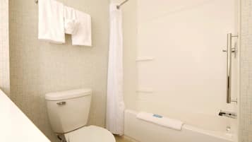 Un baño con inodoro, bañera y cortina de ducha.