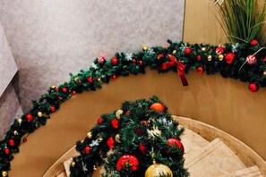 Una escalera decorada con una guirnalda navideña y un pequeño árbol de Navidad.