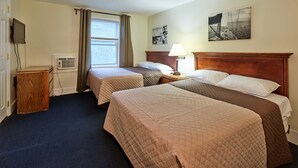 A hotel room with two beds, a TV, a desk, and a window with curtains. - Atlantic Sands (Hampton)