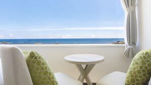 A balcony with a view of the sea, two chairs with green patterned cushions, and a small round table. - Shirahama Ocean Resort (Minamiboso)