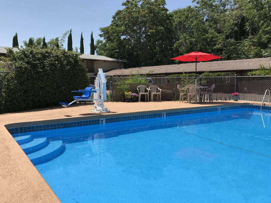 Una piscina al aire libre de temporada, sombrillas