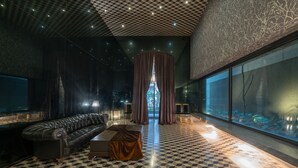 Un interior moderno con suelo a cuadros, un sofá de cuero y un ventanal con vistas.