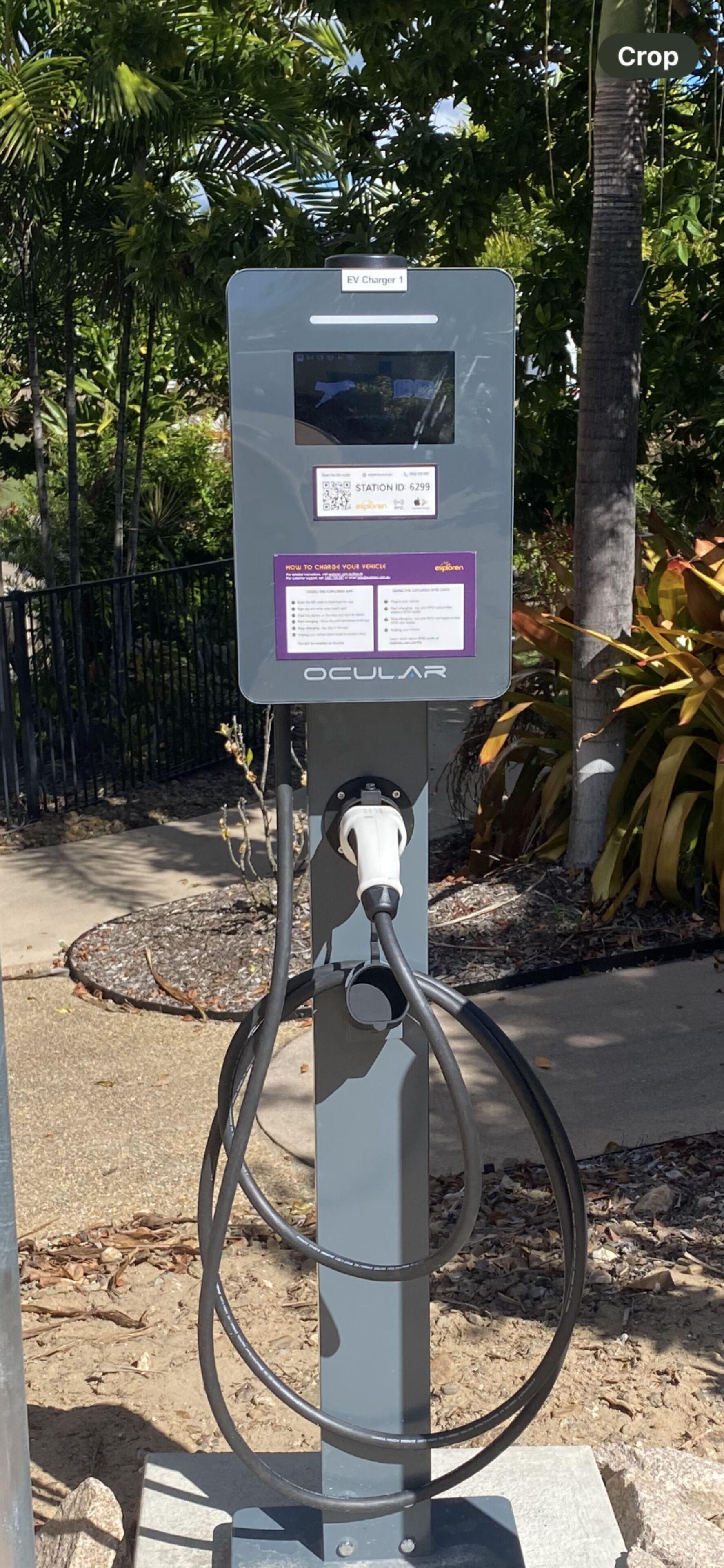 An EV charging station with a QR code, a station ID, and instructions for charging.