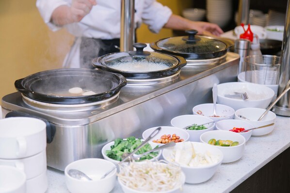 A buffet setup with various food items and containers. - The Capital Residence Suites (Bandar Seri Begawan)