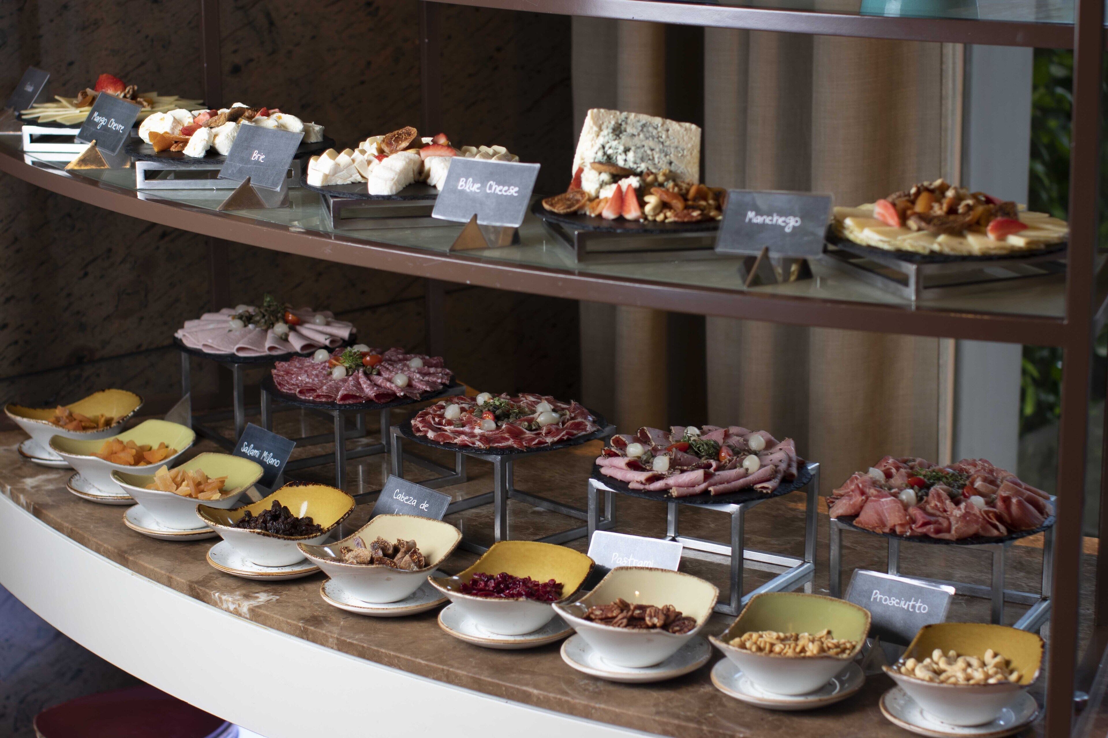 A buffet with various food items and labels.
