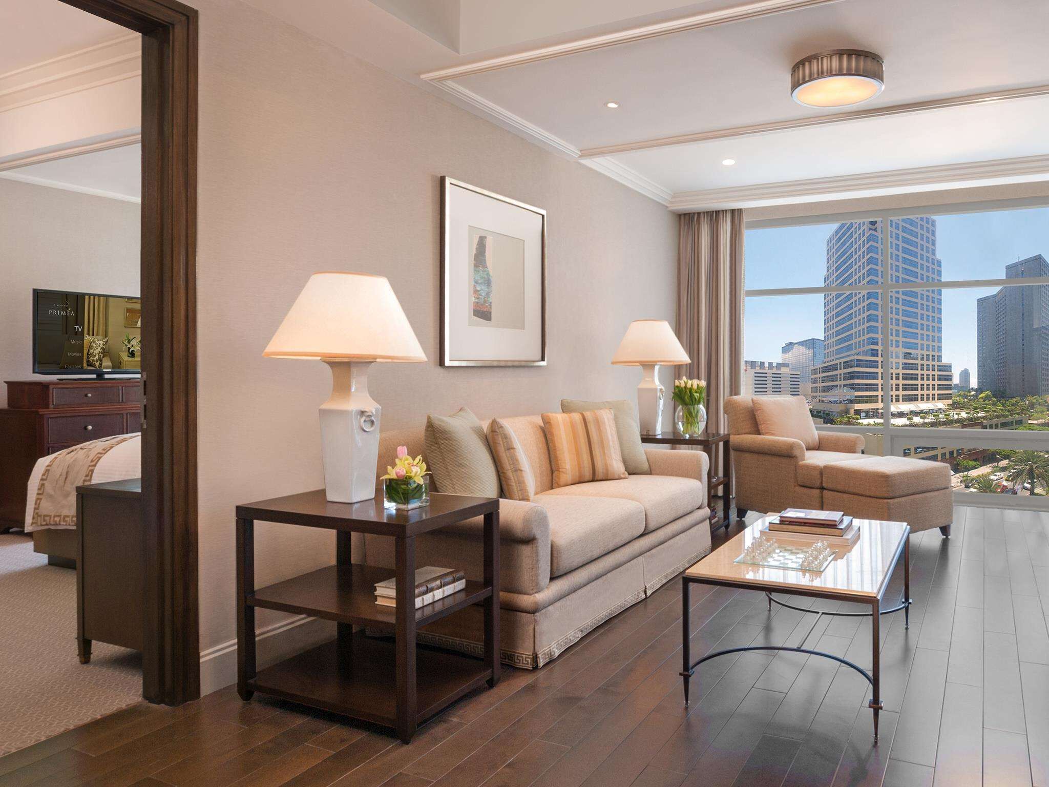 A modern living room with a sofa, armchairs, a coffee table, and a TV.