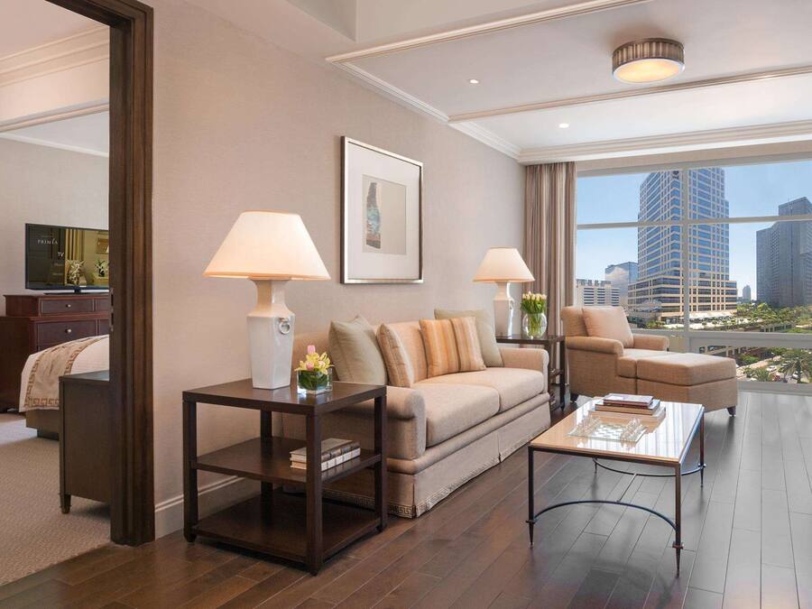 A modern living room with a sofa, armchairs, a coffee table, and a TV.