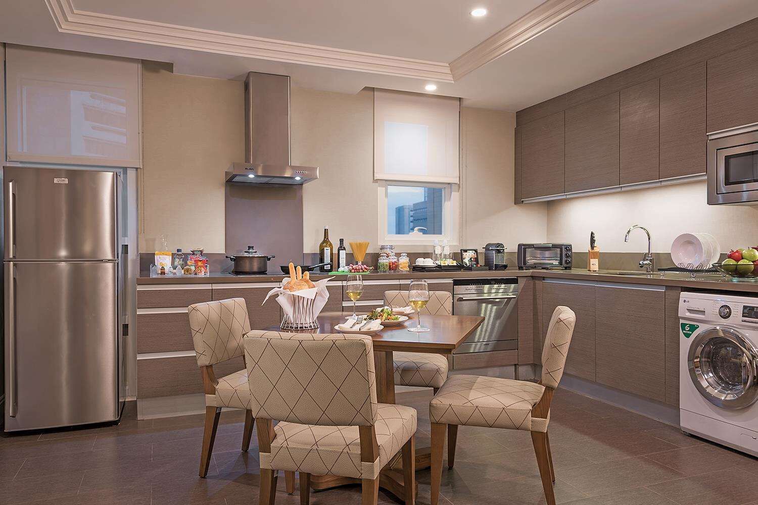 Una cocina moderna con comedor, electrodomésticos de acero inoxidable y lavadora y secadora integradas.