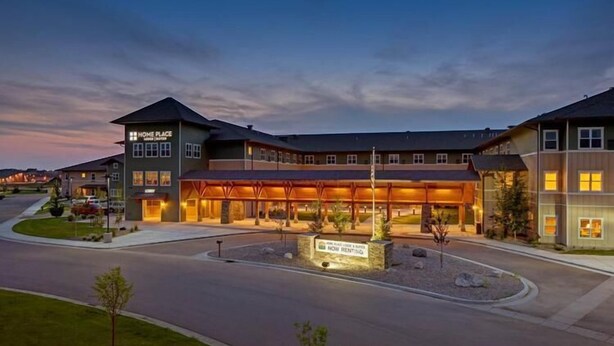 A modern hotel with a prominent entrance, a covered outdoor area, and a landscaped driveway. - Clarion Hotel & Suites Williston (Williston)
