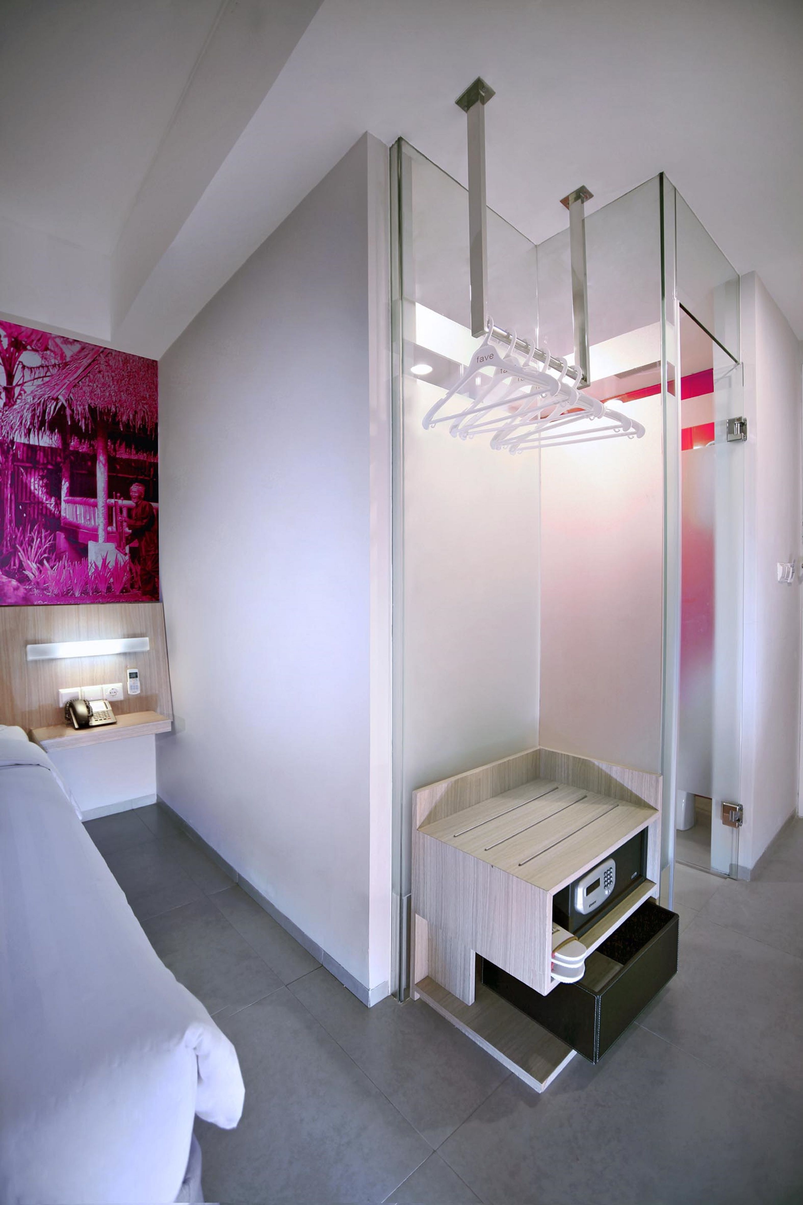 A modern bathroom with a glass shower enclosure, a built-in vanity, and a pink artwork on the wall.