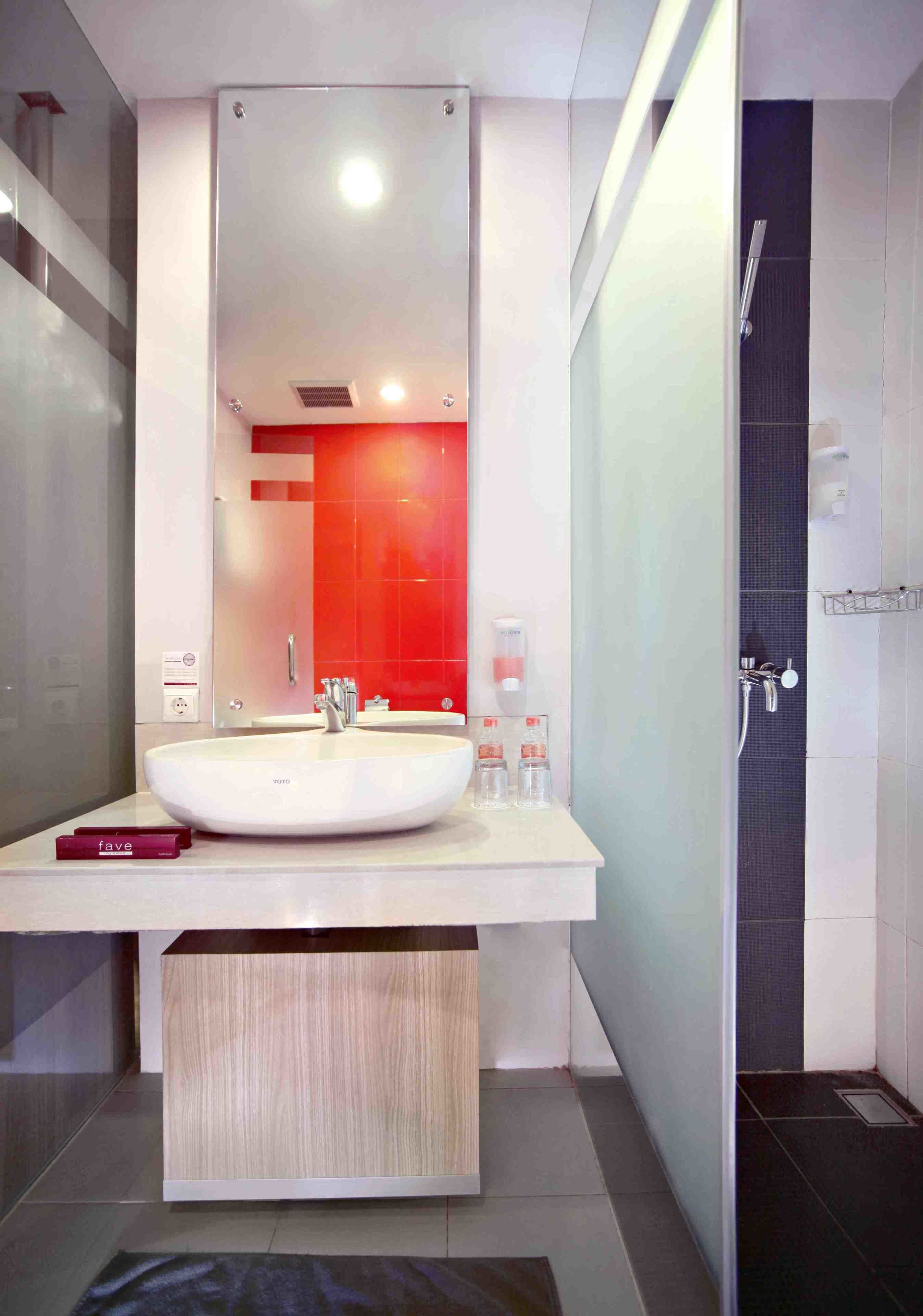 Un baño moderno con un lavamanos grande de color blanco, un espejo y una zona de ducha.