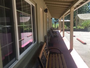 A covered outdoor seating area with benches and large windows. - Dunsmuir Lodge (Dunsmuir)