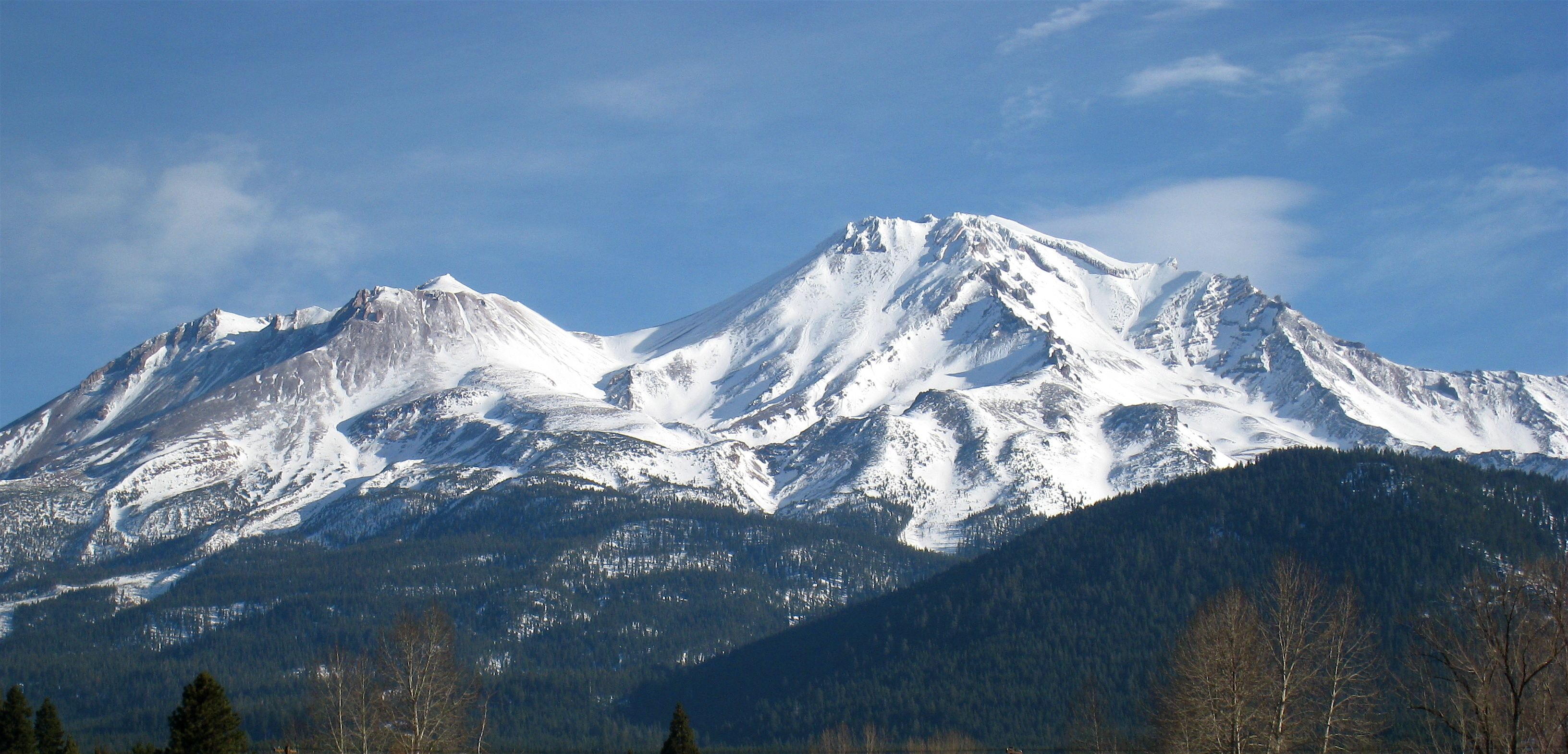 Ein verschneites Gebirge bei klar blauem Himmel.