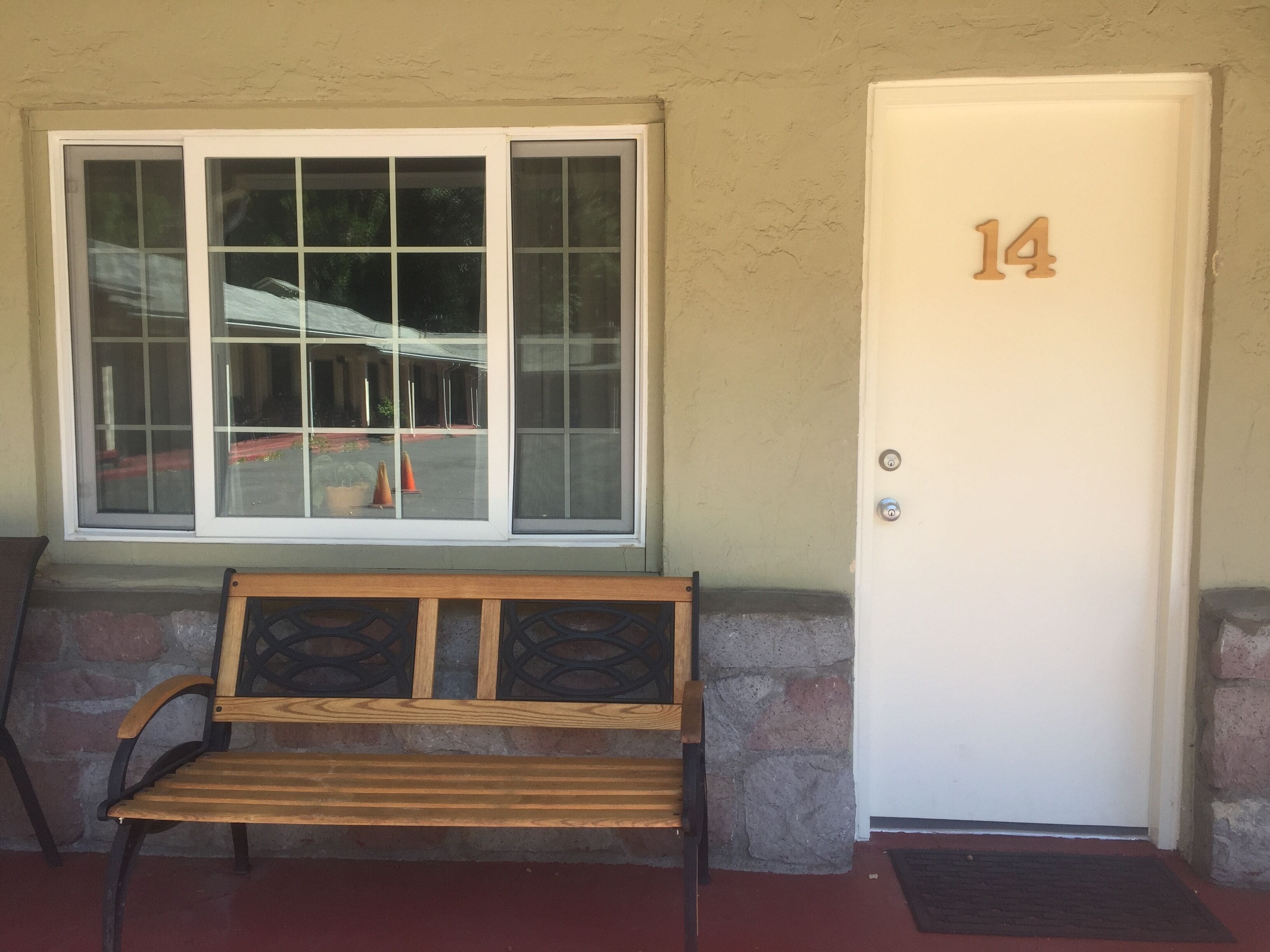 A bench outside a building with a door marked "14".