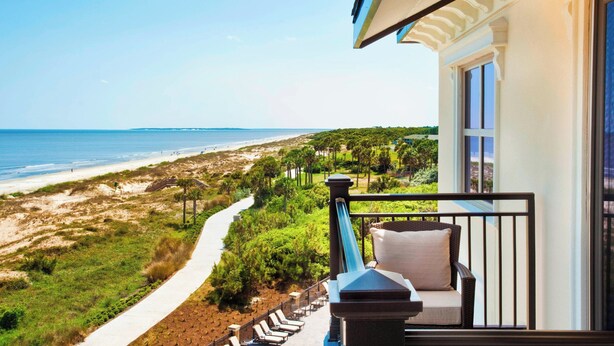 Un balcón con vista a la playa y al océano.