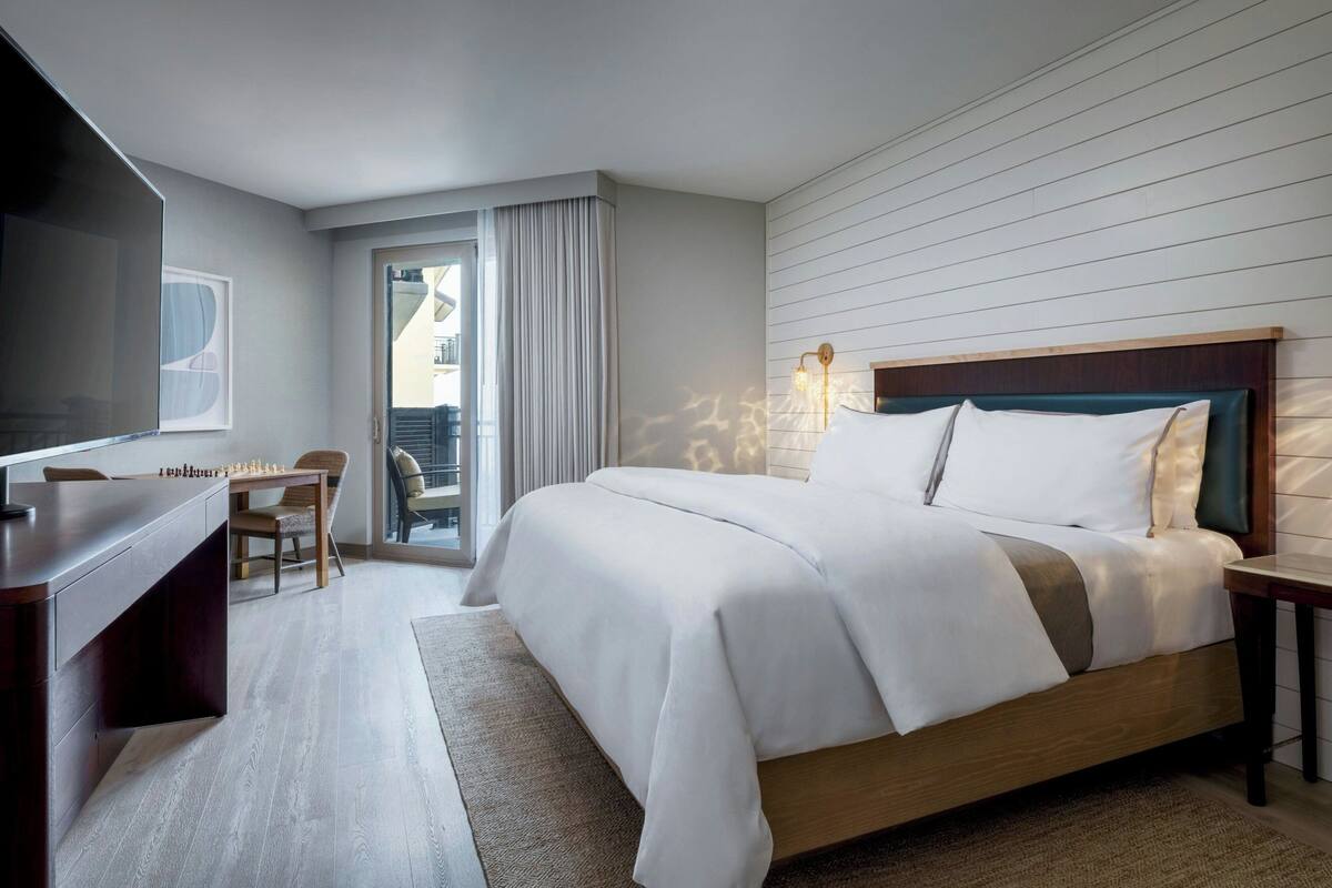 Une chambre d’hôtel équipée d’un lit, d’un bureau, d’une chaise et d’un téléviseur.