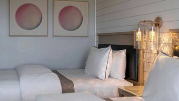 A hotel room with a bed, a nightstand, and a wall-mounted lamp.