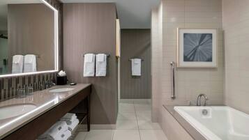 A modern bathroom with two sinks, a bathtub, and a shower.