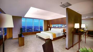 A modern hotel room with a large bed, a desk, a chair, and a view of the city.