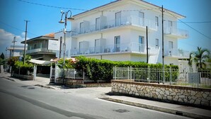 A multi-story hotel with balconies, a stone facade, and a clear blue sky. - Minturnae Hotel (Minturno)