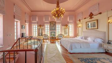 Un dormitorio amplio con una cama grande, un candelabro y vistas a la ciudad.