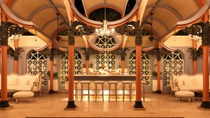 A luxurious interior with ornate columns, a bar area, and a seating arrangement. - La Maison Bleue (El Gouna)