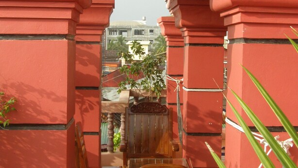 Un arco de entrada con paredes rojas y un banco de madera.