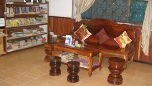 Una sala de estar con un sofá de madera, una mesa de centro y una estantería llena de libros.